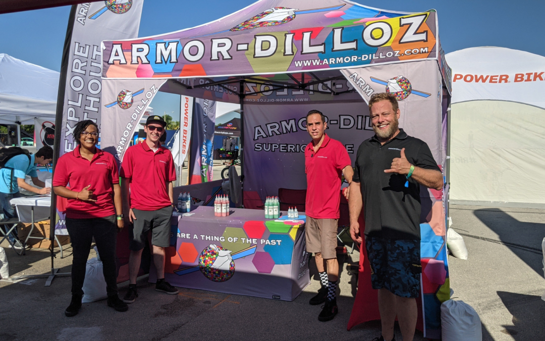 The Armor-Dilloz team poses at their vendor tent during a Onewheel event.