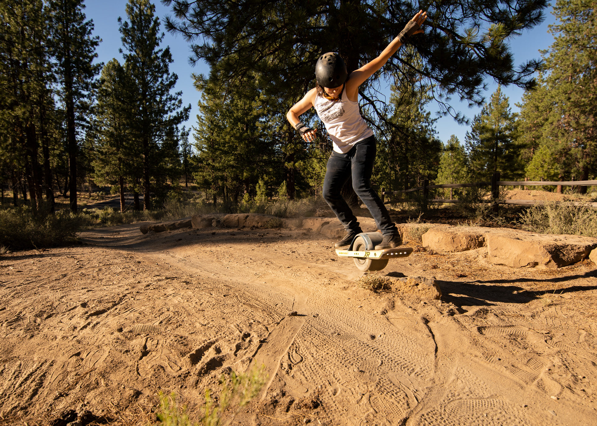 Racheal Cecil bonks her onewheel over a rock in the high desert of Bend, Oregon.